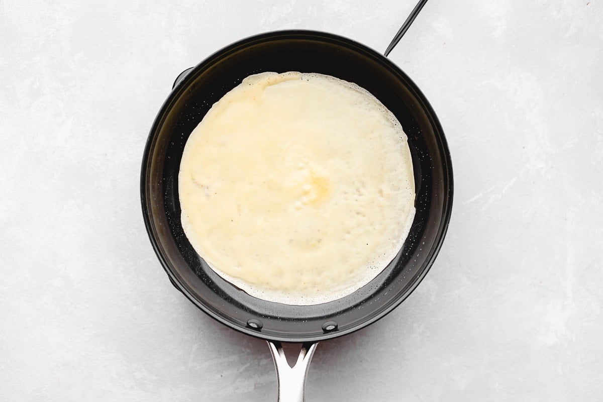 crepe cooking in a skillet. 