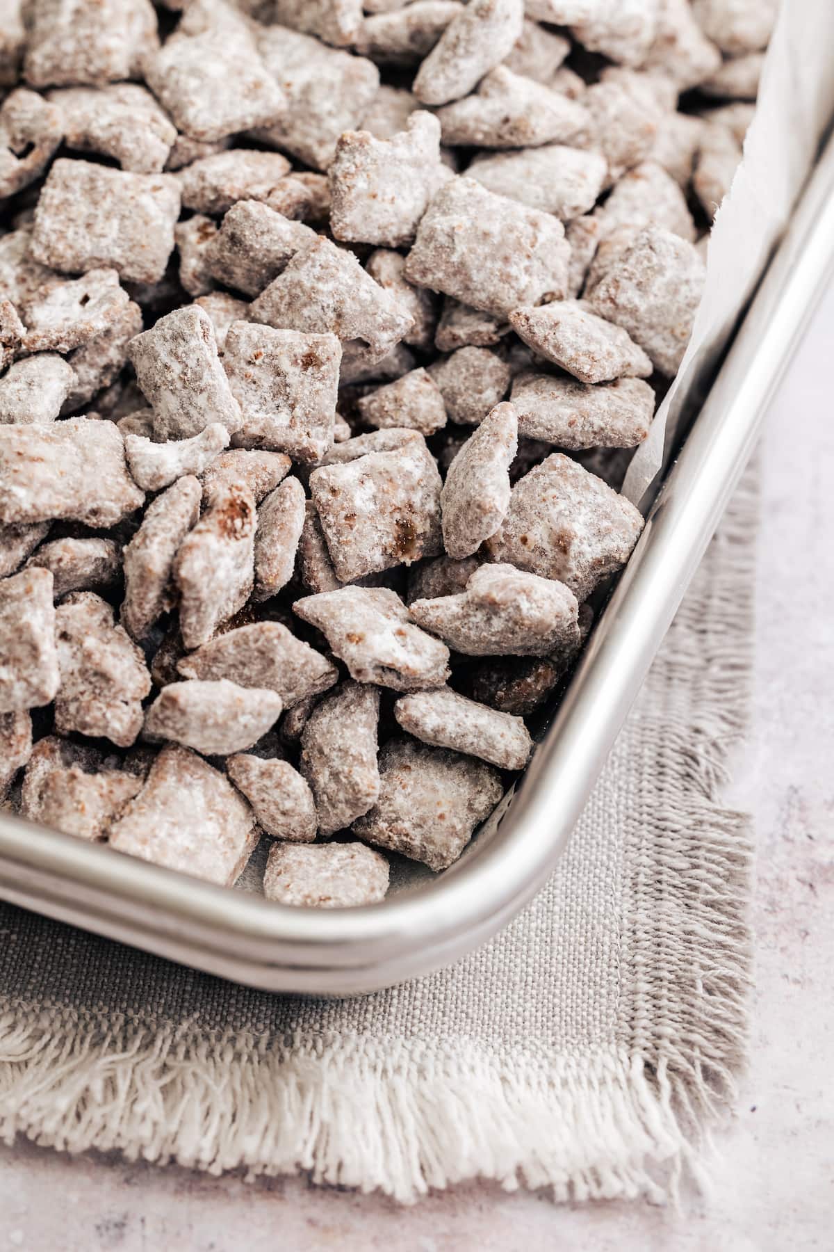 The corner of a metal pan filled with homemade puppy chow.